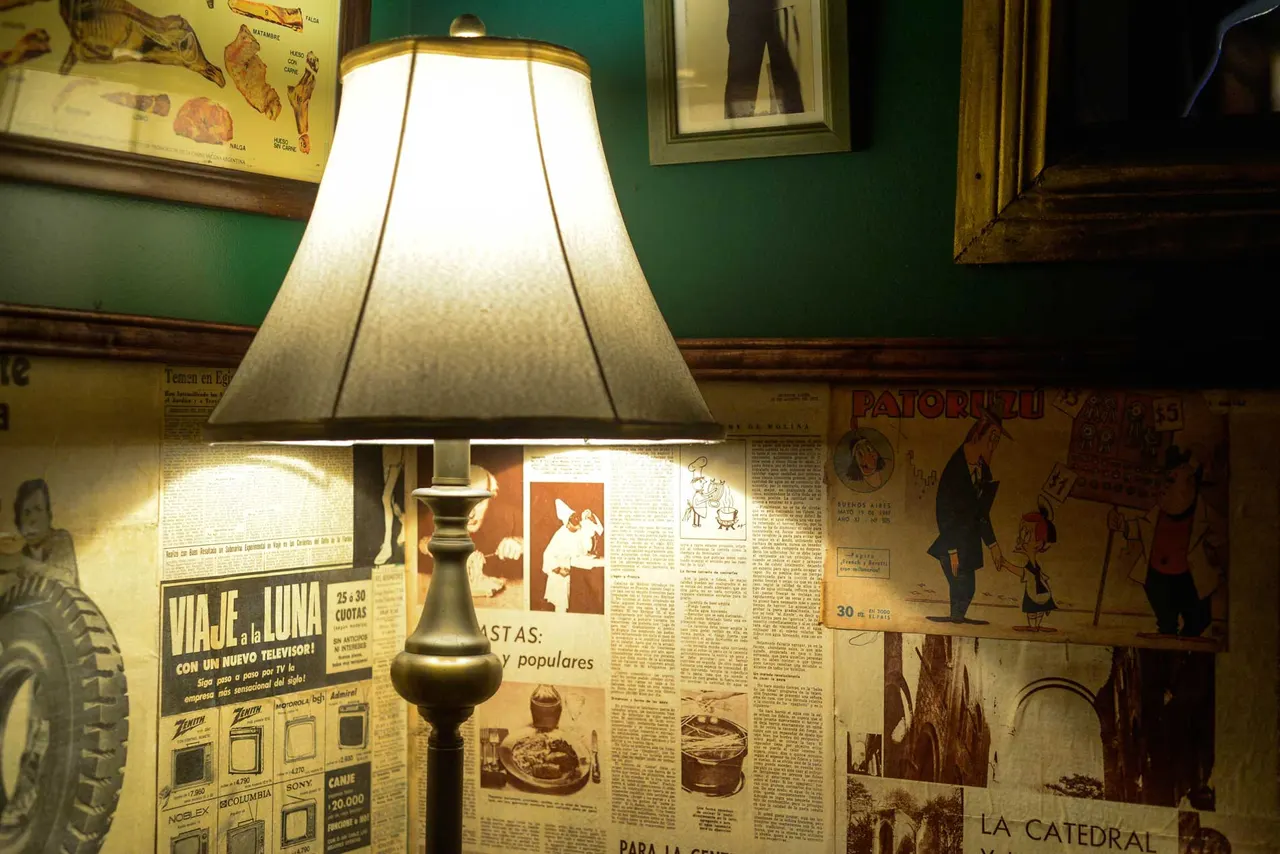 Lámpara y recortes de época en la decoración del restaurante