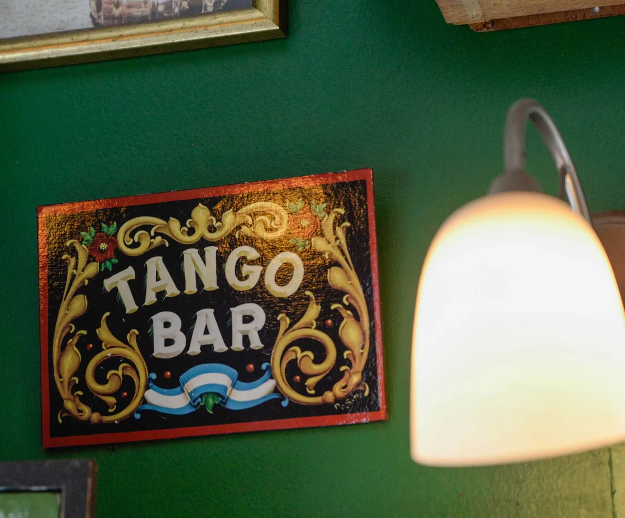 Cartel de Tango Bar junto a una lámpara