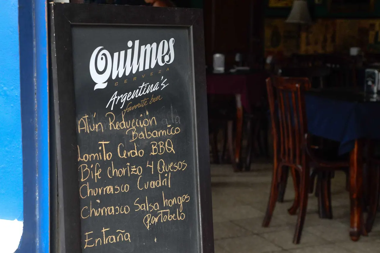 Pizarra de bebidas en la entrada al salón