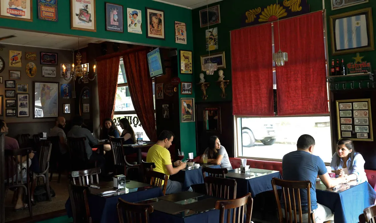 Vista del salón hacia las ventanas y las cortinas rojas