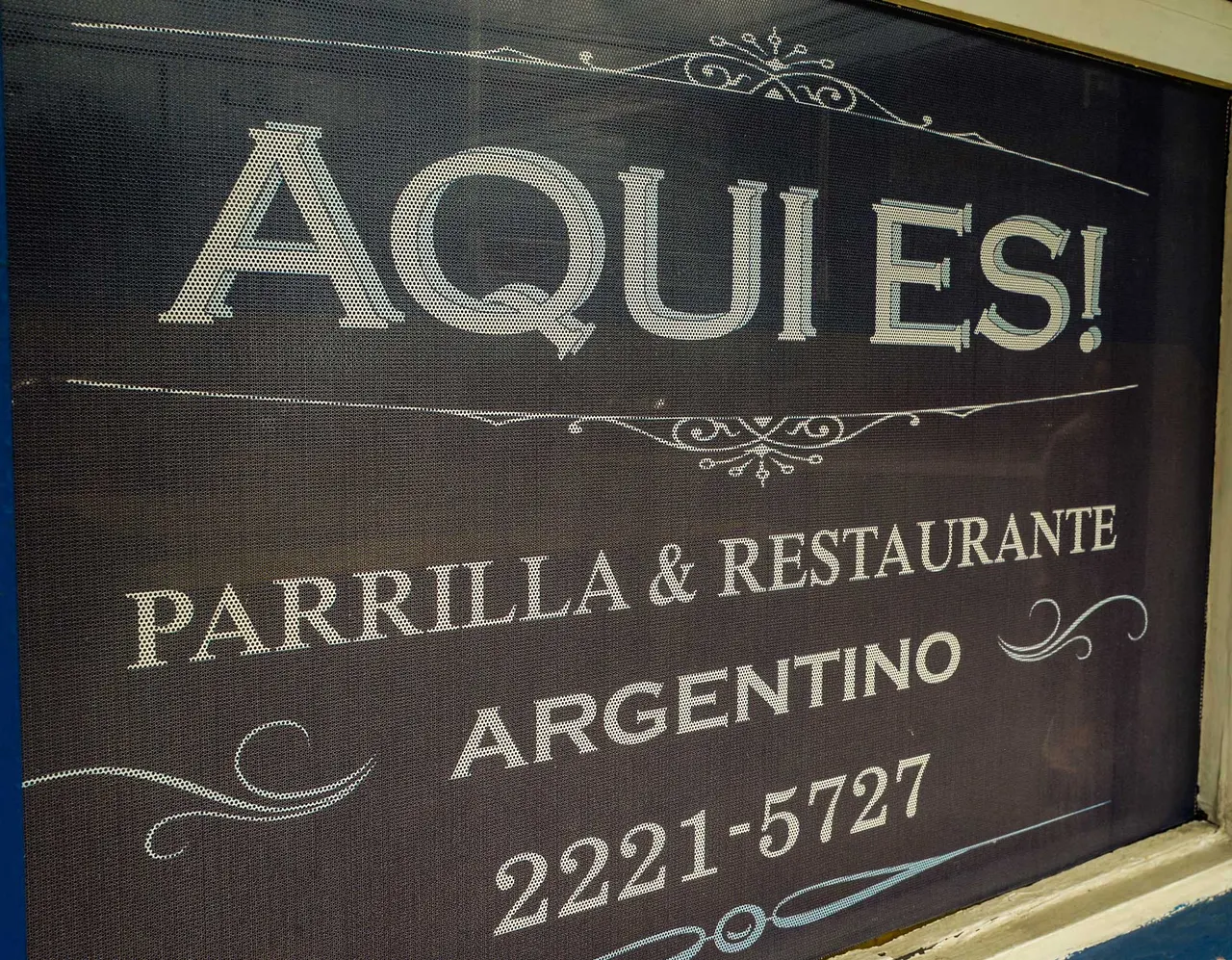Letrero original de Aquí Es, parrilla y restaurante argentino