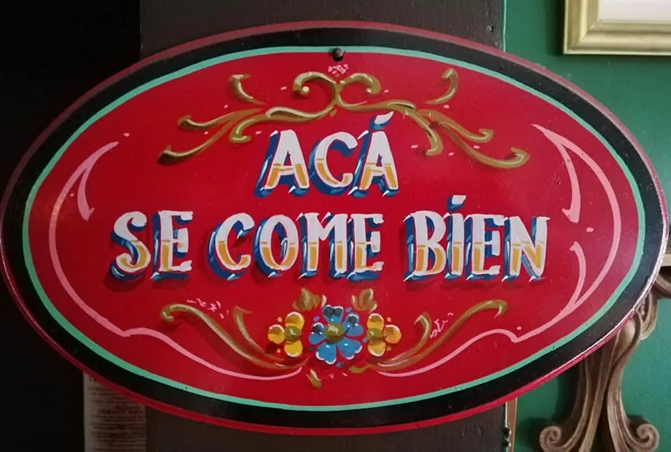 Cartel decorativo con la frase Acá se come bien