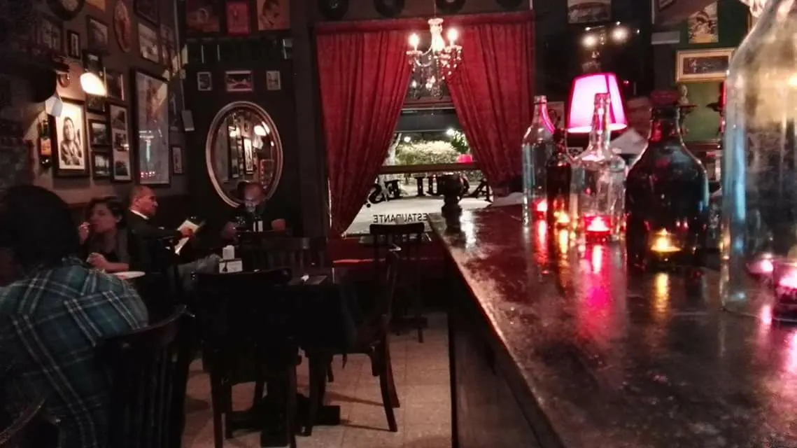 Mesas del restaurante junto a cortinas rojas