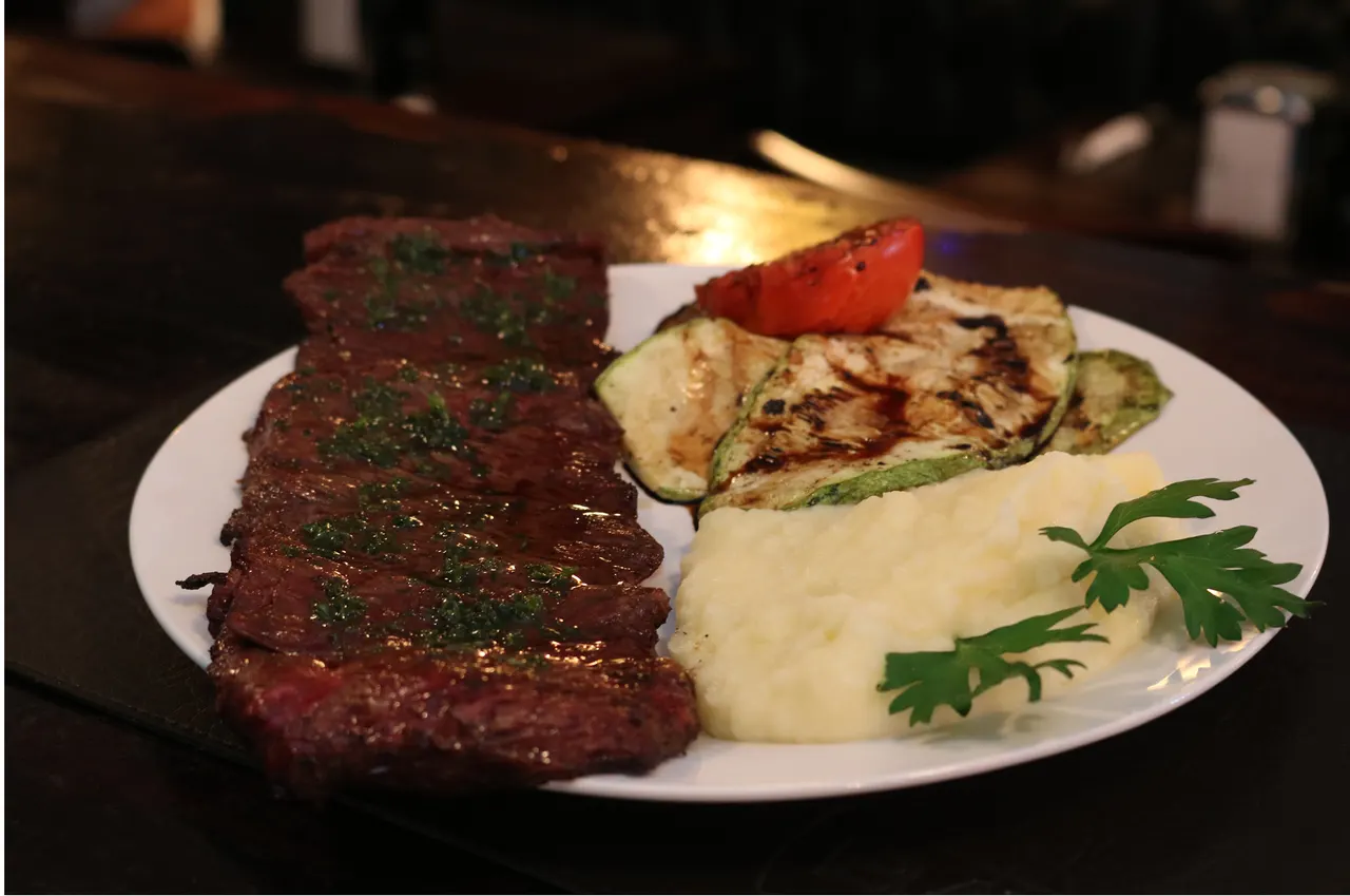 Carne a la parrilla con puré y guarniciones