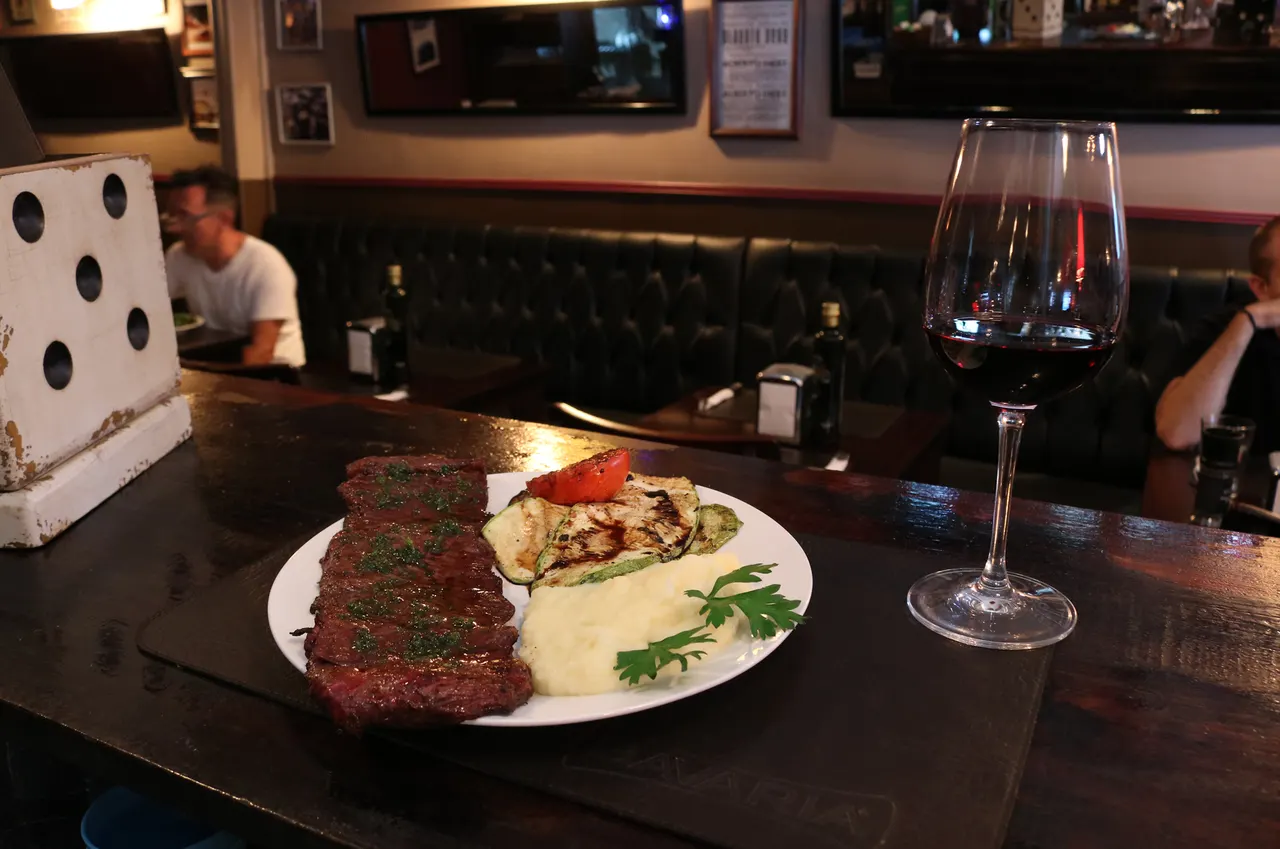 Plato de carne y guarniciones frente a la barra