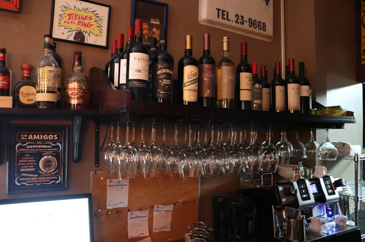 Botellas de vino y copas colgadas en un estante
