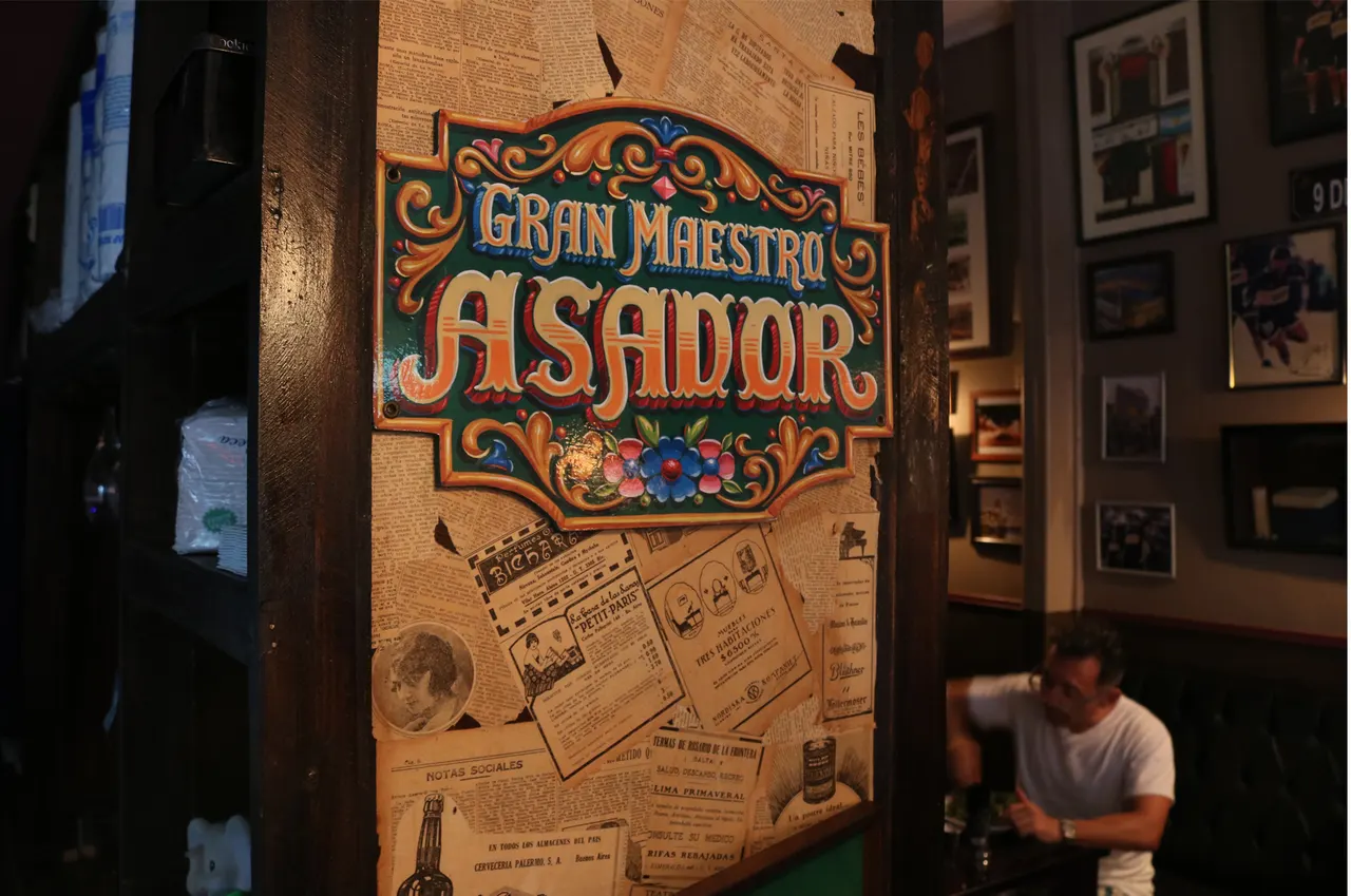 Cartel del Gran Maestro Asador entre los recuerdos del salón