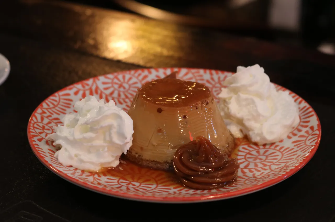 Flan servido con crema y dulce de leche