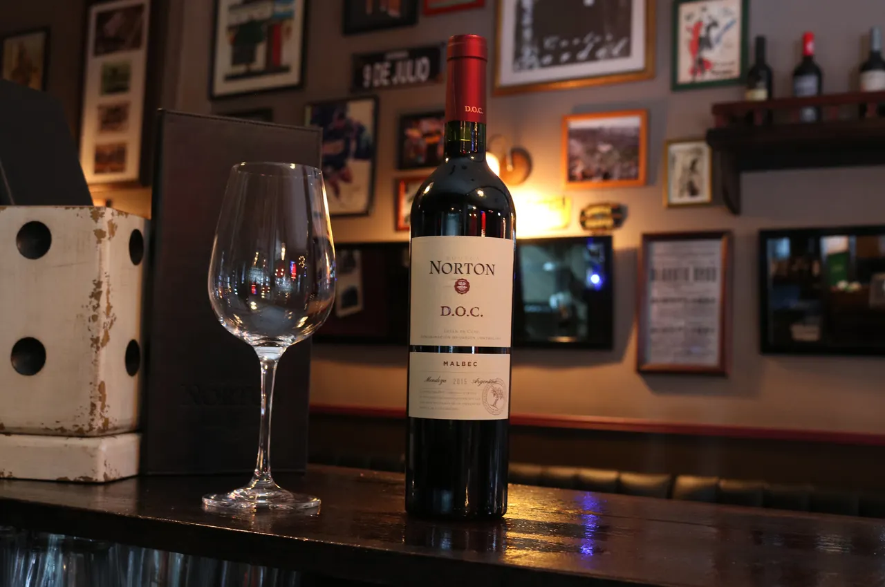 Presentación de una botella de vino y una copa